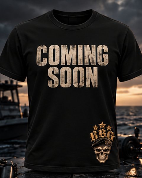 Black tee with Coming Soon across the chest and the RBG skull-in-beret on the hem, on a boat deck at dusk
